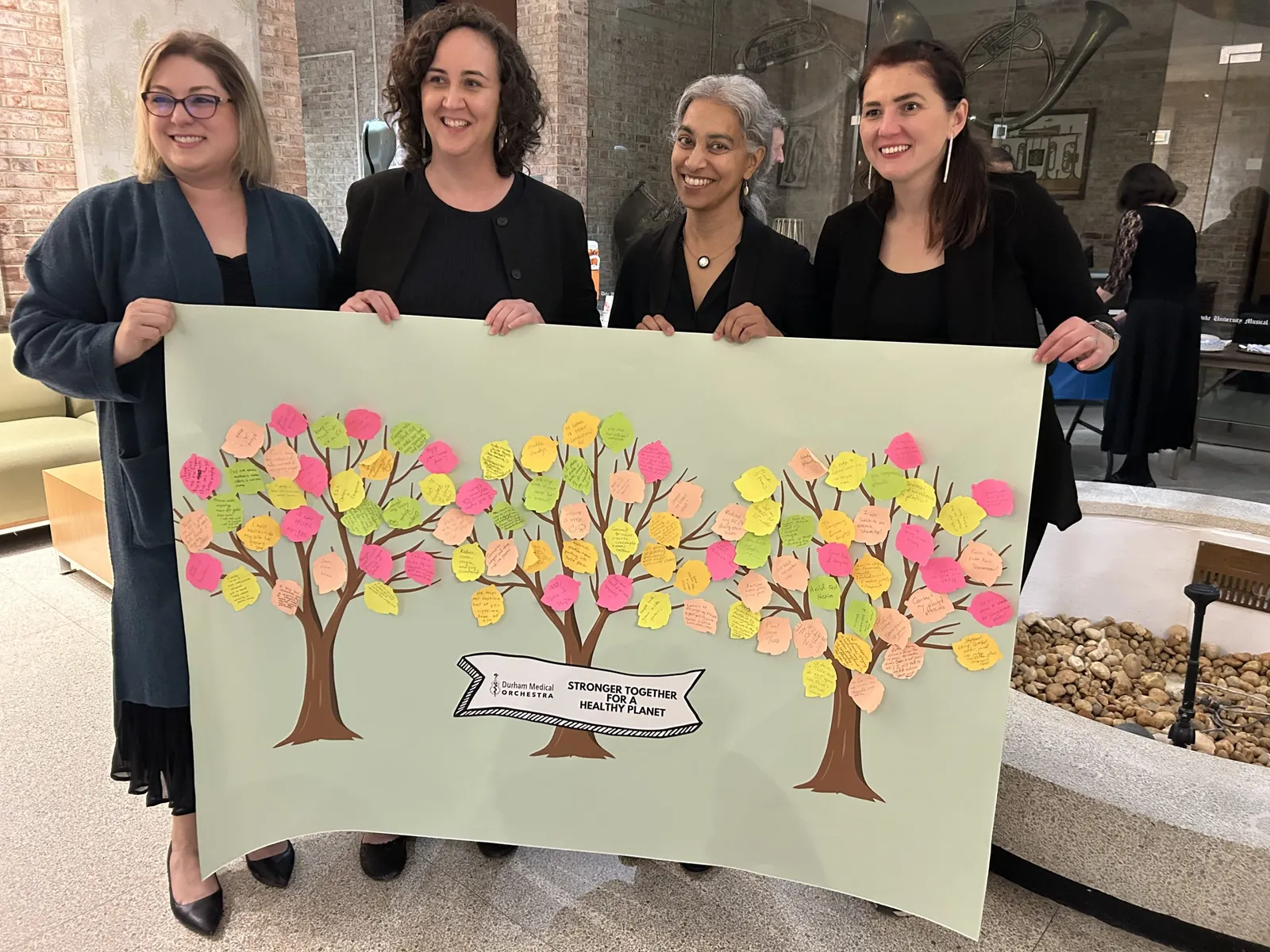 Durham Medical Orchestra members with a community art collaboration