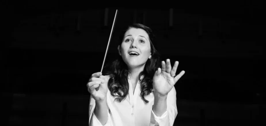 Verena Mösenbichler-Bryant conducting the Durham Medical Orchestra, baton raised